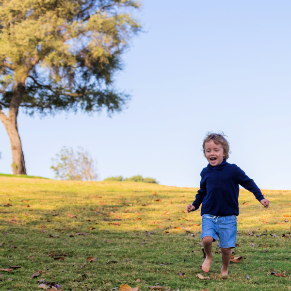 Boy wearing shorts and jumper running down a hill.
My little child vegetarian.